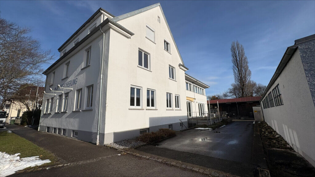 Rückwärtige Außenansicht des Bestandsgebäudes mit Zufahrt, Nebengebäuden und barrierefreiem Zugang im ruhigen Innenhof.